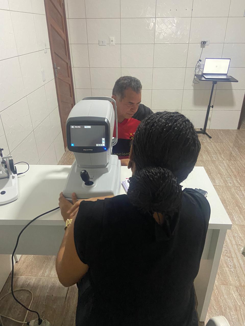 Profissional operando autorrefrator com paciente